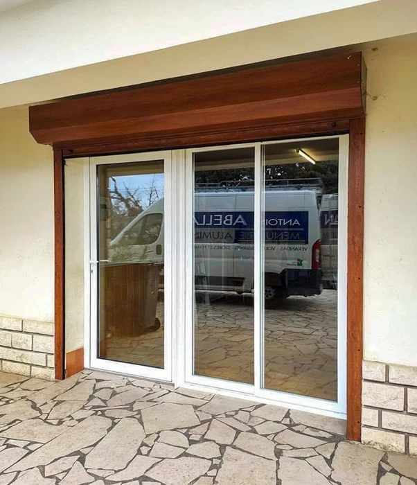 Maison contemporaine à architecture moderne avec terrasse couverte aménagée en salon extérieur, jardin paysagé et pelouse entretenue