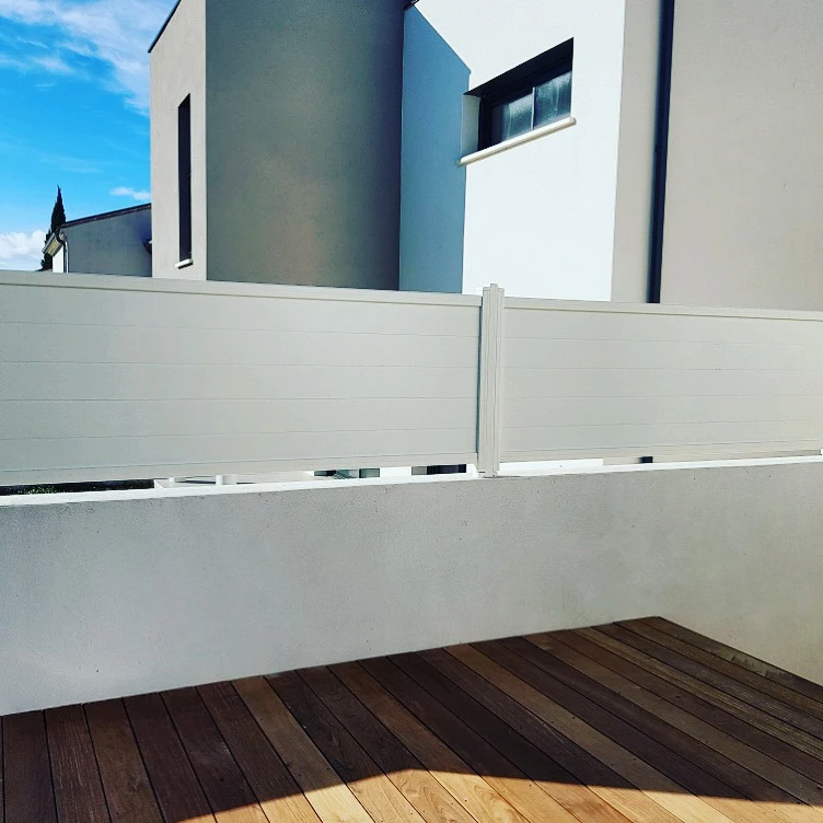 Portail d'entrée moderne en bois et métal installé devant une maison contemporaine avec jardin paysager