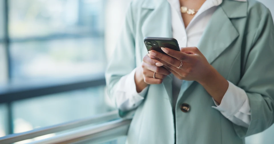 Mains tenant un smartphone dans un environnement intérieur sombre avec effets lumineux bleus